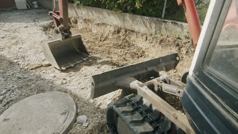 Parallax-shot-of-a-mini-excavator-standing-on-a-drive-way-at-the-evening