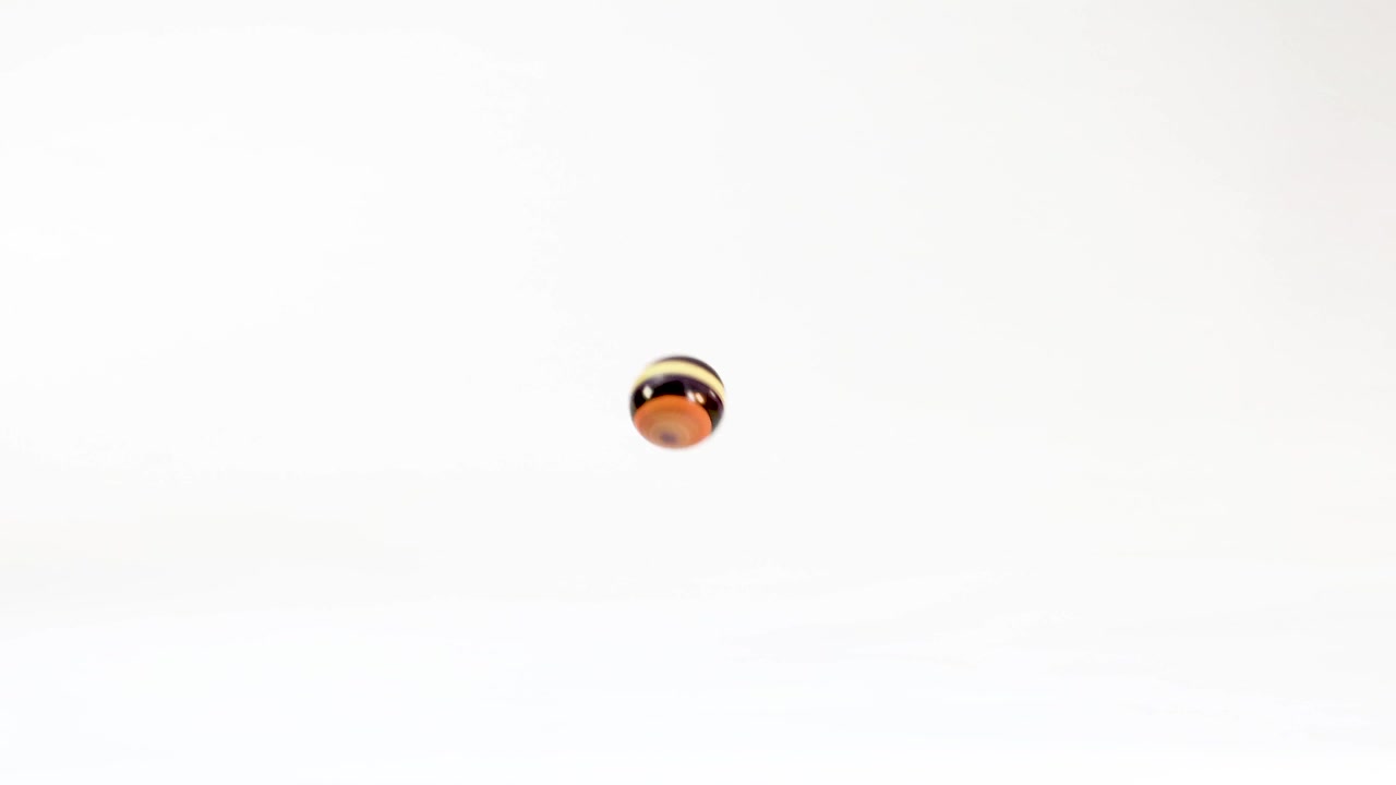 Red, Blue, and Globe Marbles Rolling in Slow Motion
