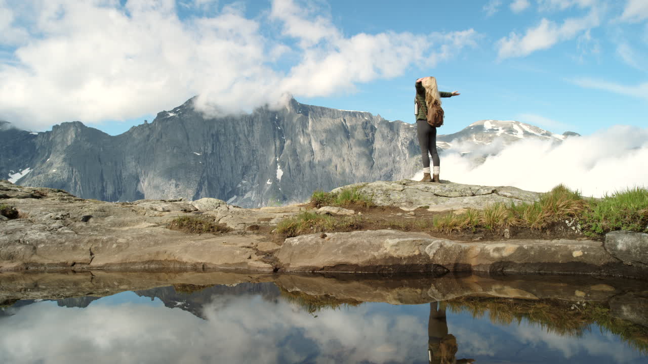 mujer caminando en majestuosas montañas con reflejo