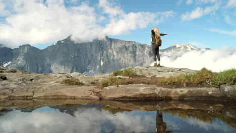 woman hiking in majestic mountains with reflection