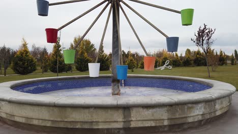 water wheel with colorful water buckets in a park