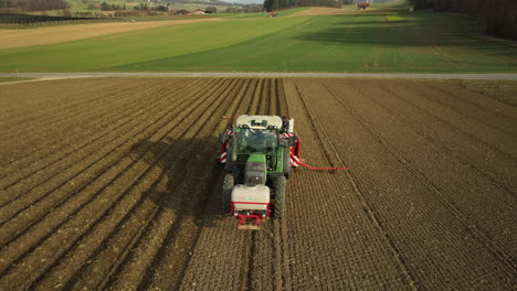 tractor driving over a potato farm field