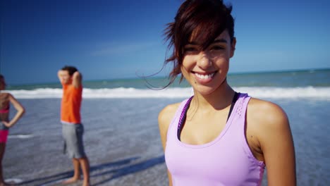 portrait of hispanic woman stretching on beach vacation