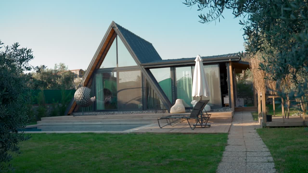 mano de mujer sostiene las llaves caminando en el patio a la casa de lujo