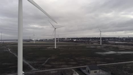 sustainable electrical wind turbines spinning on england farmland