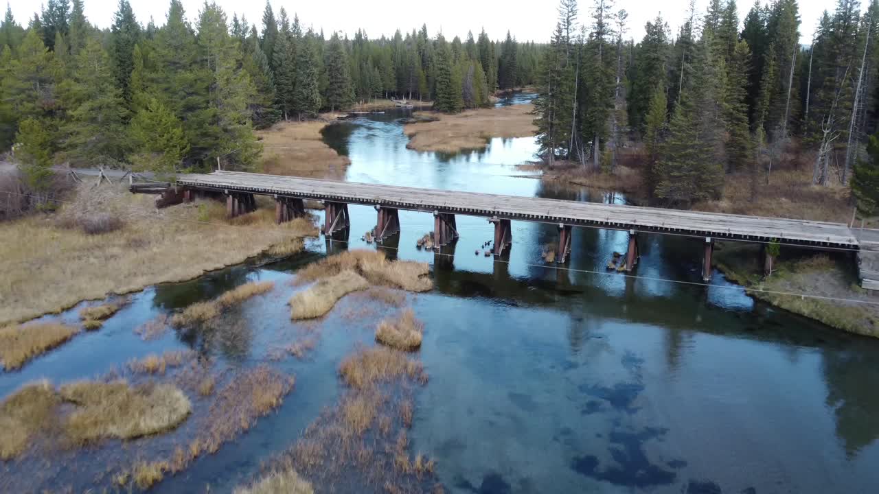 Scatto panoramico aereo di Island Park, in Idaho, con fiume dalle acque calme, zona paludosa e una baita isolata nella foresta. Ottimo per video di viaggi regionali.