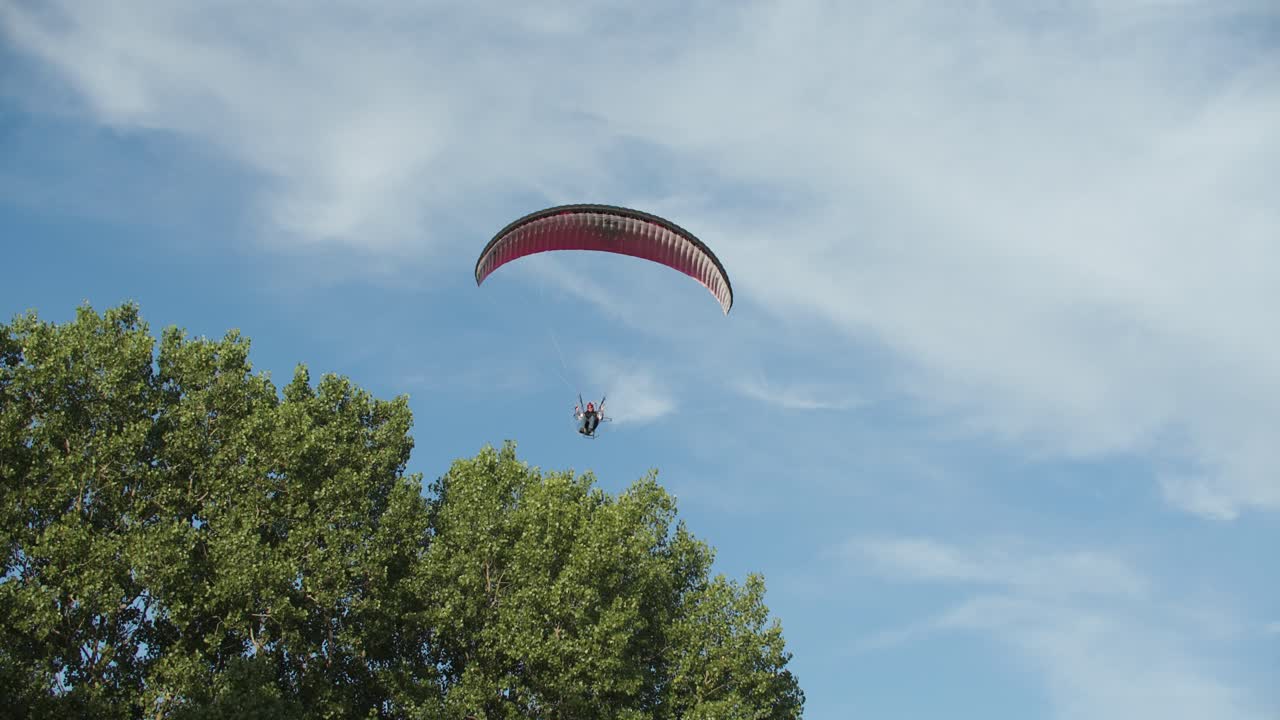 Paralayang terbang melewati pohon di langit Wisconsin.