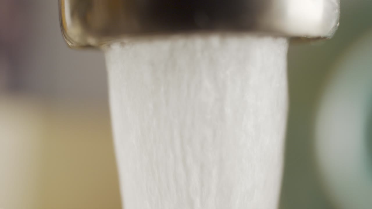 물을 낭비하는 떨어지는 수도꼭지의 매크로 샷