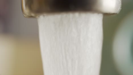 tomas macro de un grifo de agua que gotea desperdiciando agua
