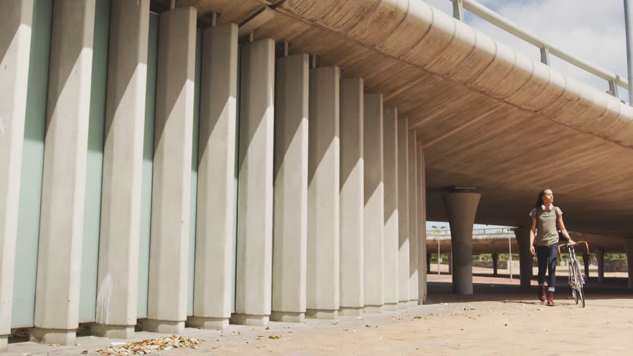 Mixed race man walking with a bike