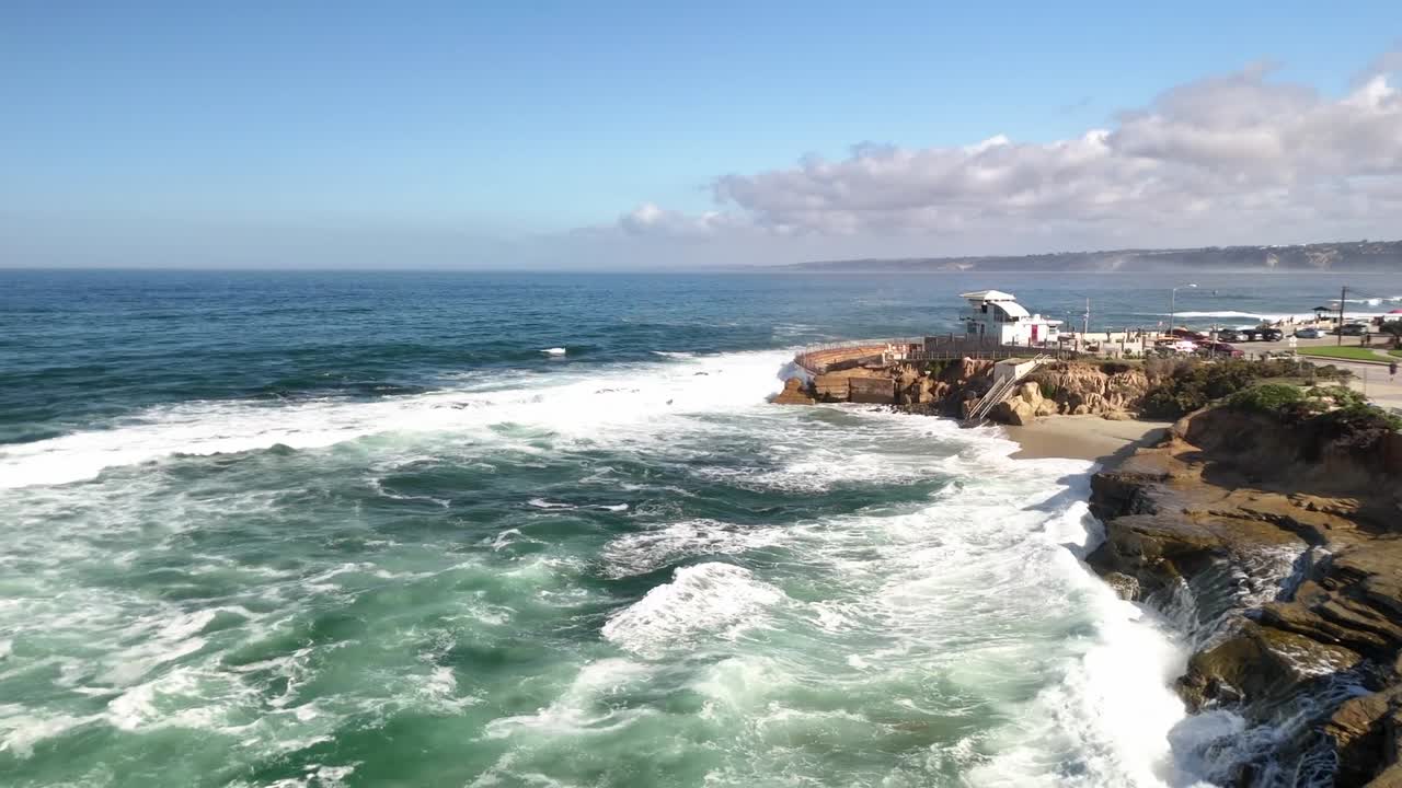 A broad daytime shot capturing the full curve of the shoreline near San Diego California