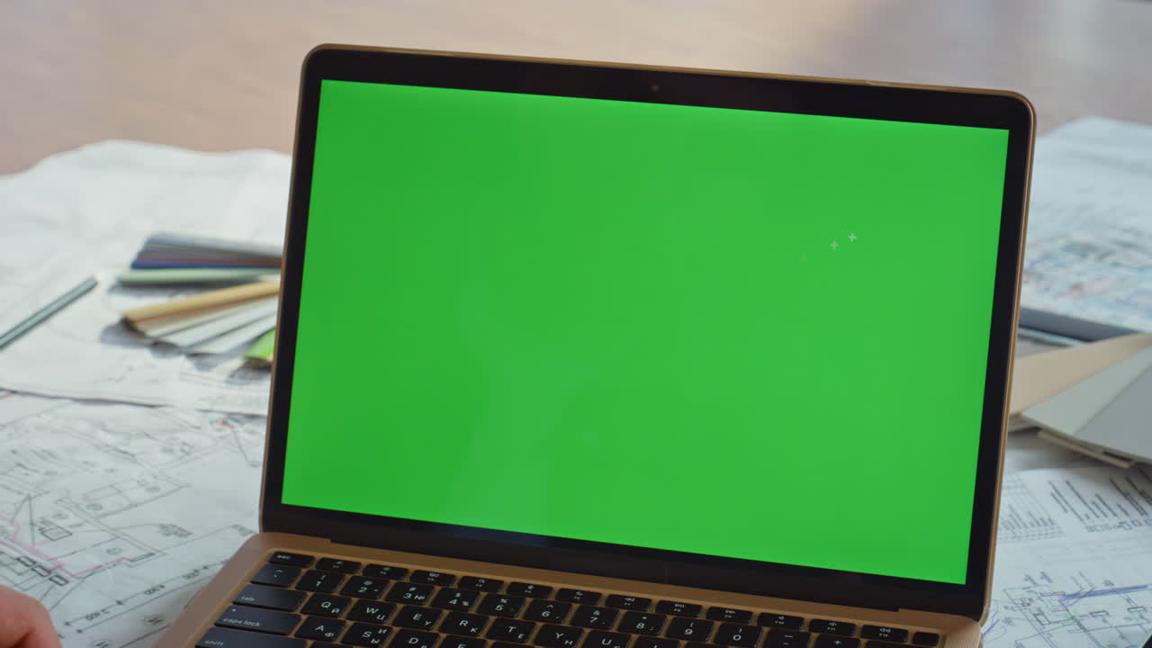 Creative manager surfing chromakey laptop at architectural office desk closeup