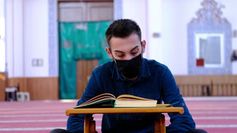 Joven-Lleva-Una-Máscara-Y-Lee-El-Corán-En-La-Mezquita