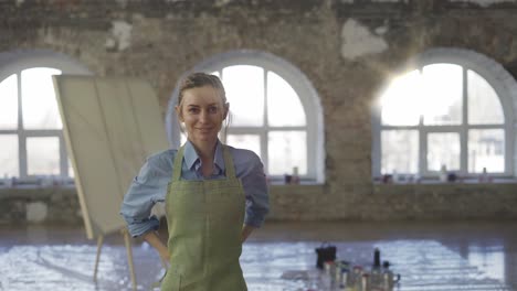 portrait woman put on apron to start painting in large workshop