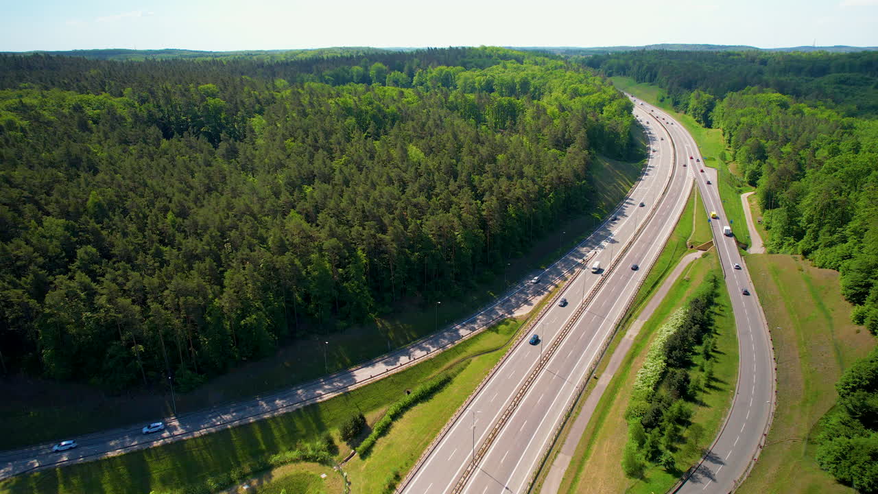 vehículos que pasan por una autopista y una autopista que pasa por el bosque verde en gdynia, polonia