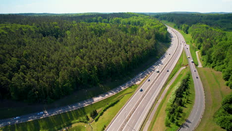 vehicles running through an expressway and highway passing by green forest in gdynia, poland