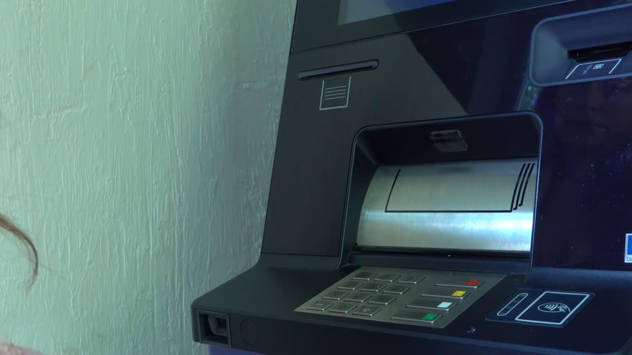 Woman taking out a card and money from an ATM