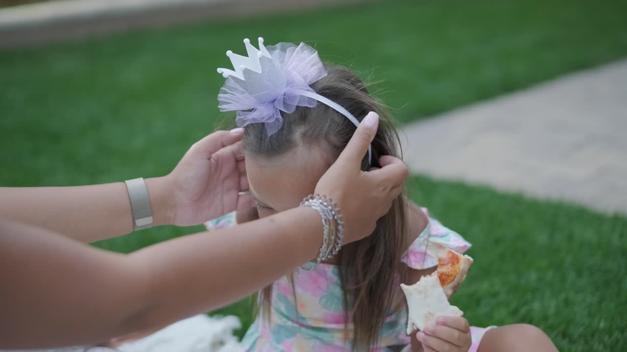 엄마와 어린 딸이 뒷마당에서 담요 위에 앉아 함께 그림을 그리고 있습니다. 야외 장면은 평화로운 가족 순간을 포착하여 창의성과 유대를 촉진합니다.