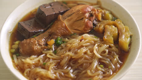 stewed chicken noodle in brown soup bowl - asian food style