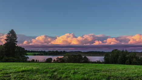 video de lapso de tiempo de paisaje de nubes hinchadas blancas en rápido movimiento en el cielo azul claro sobre el paisaje rural con praderas verdes y lago en el tiempo de la tarde