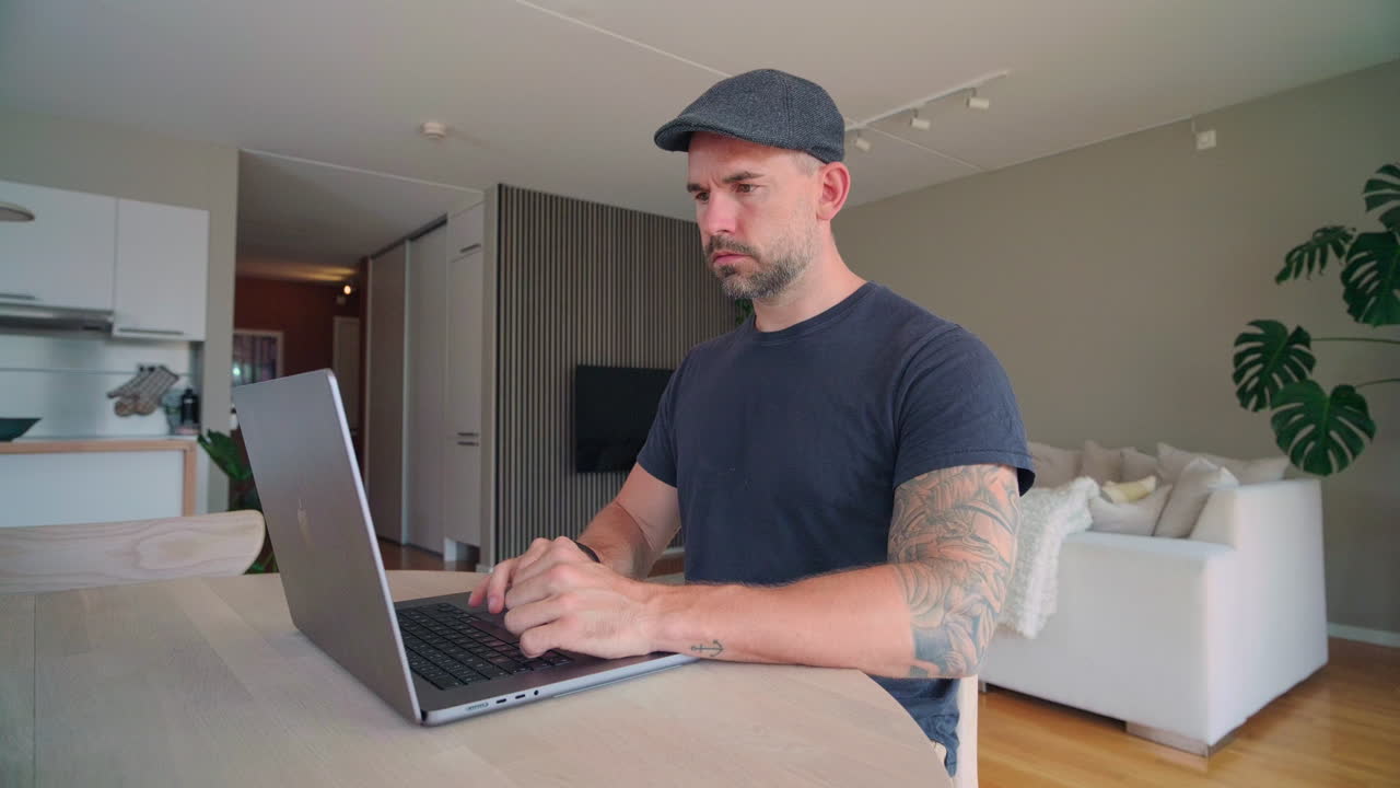 hombre casual trabajando en una computadora portátil en casa - de cerca