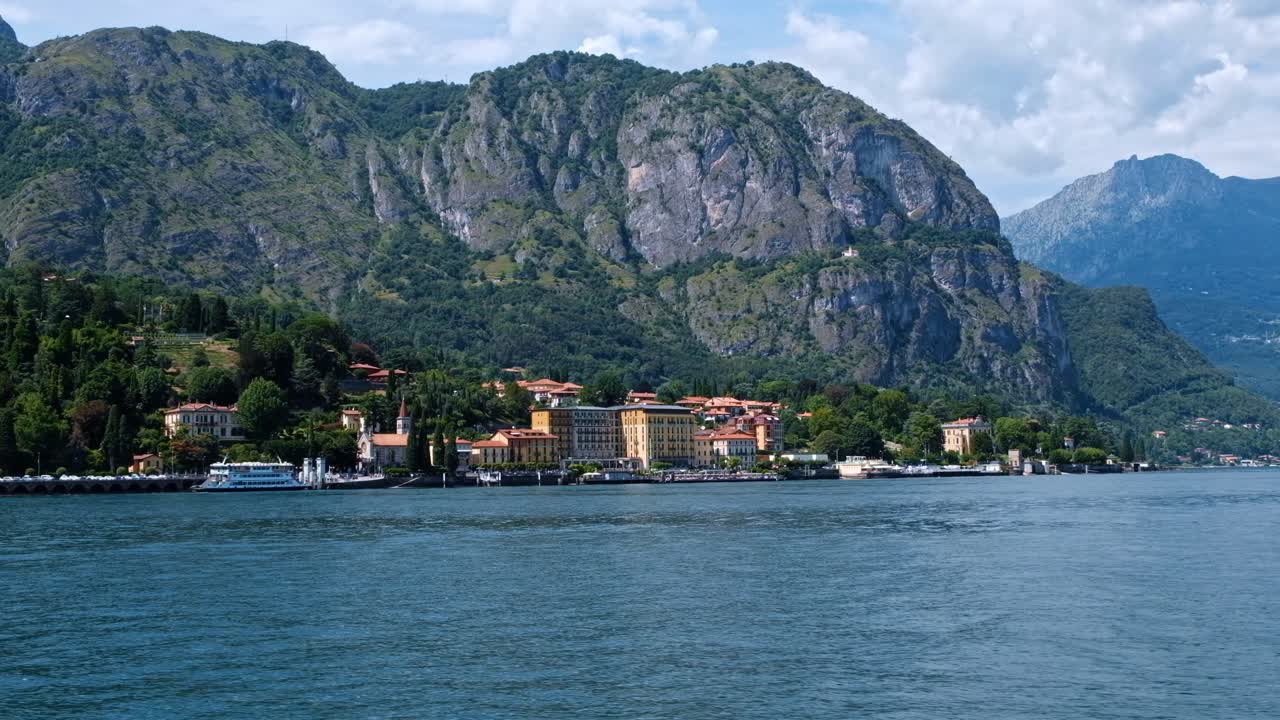 Cinematic shot of Bellagio town, Como lake and mountains from a boat in Lombardy, Italy