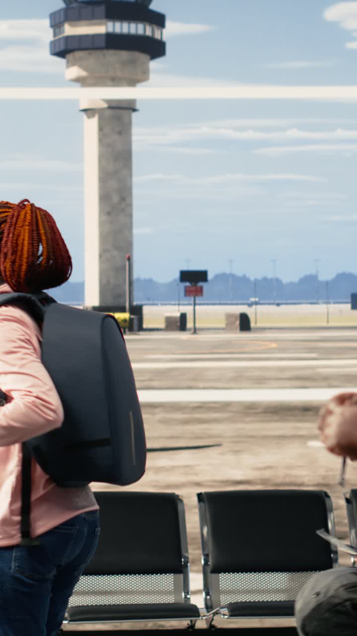 Pareja feliz abrazándose en la ventana de la terminal del aeropuerto.