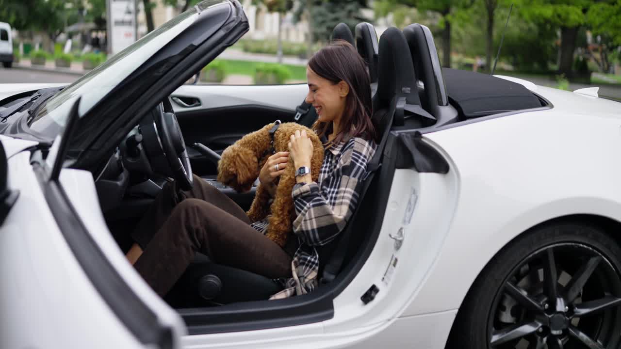 mujer feliz conduciendo en un descapotable con su perro