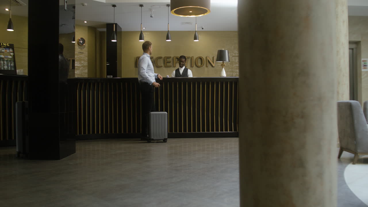 Man checking in at the hotel reception desk