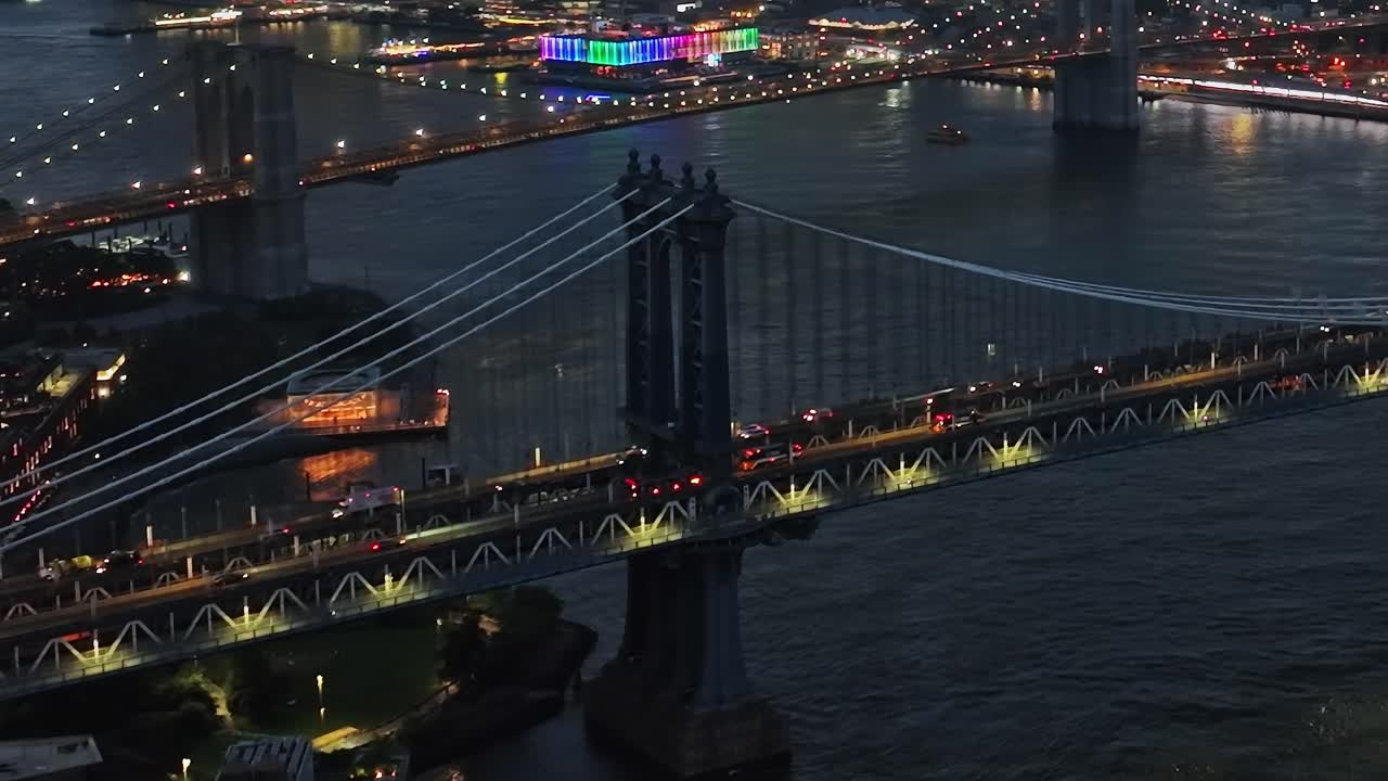 Bright night view of Manhattan Bridge over water in New York City