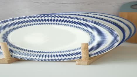 stack of patterned blue and white plates on a wooden rack