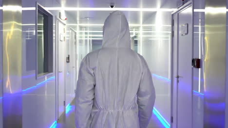 scientist researchers and technicians in a coverall conducting a research, walking through modern laboratory. people with science concept.