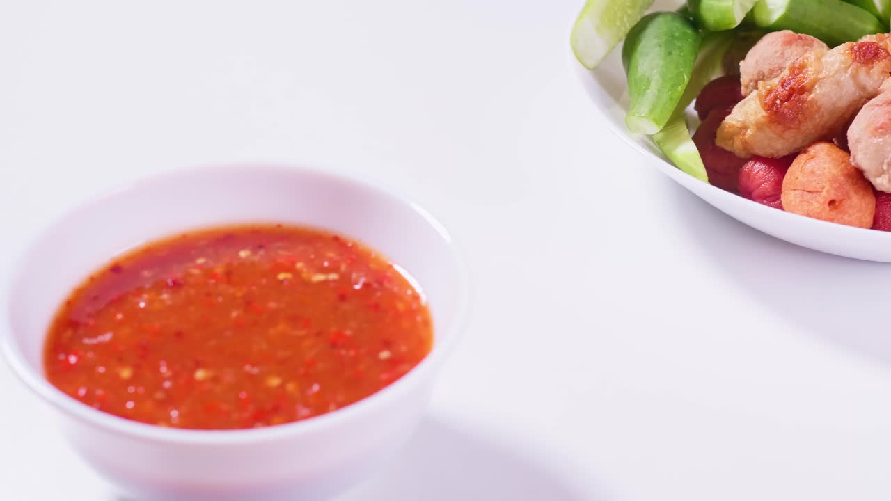 Fried meatballs and dipping sauce on a white background