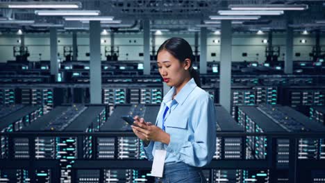 side view of asian business woman using mobile phone an looking around in data center