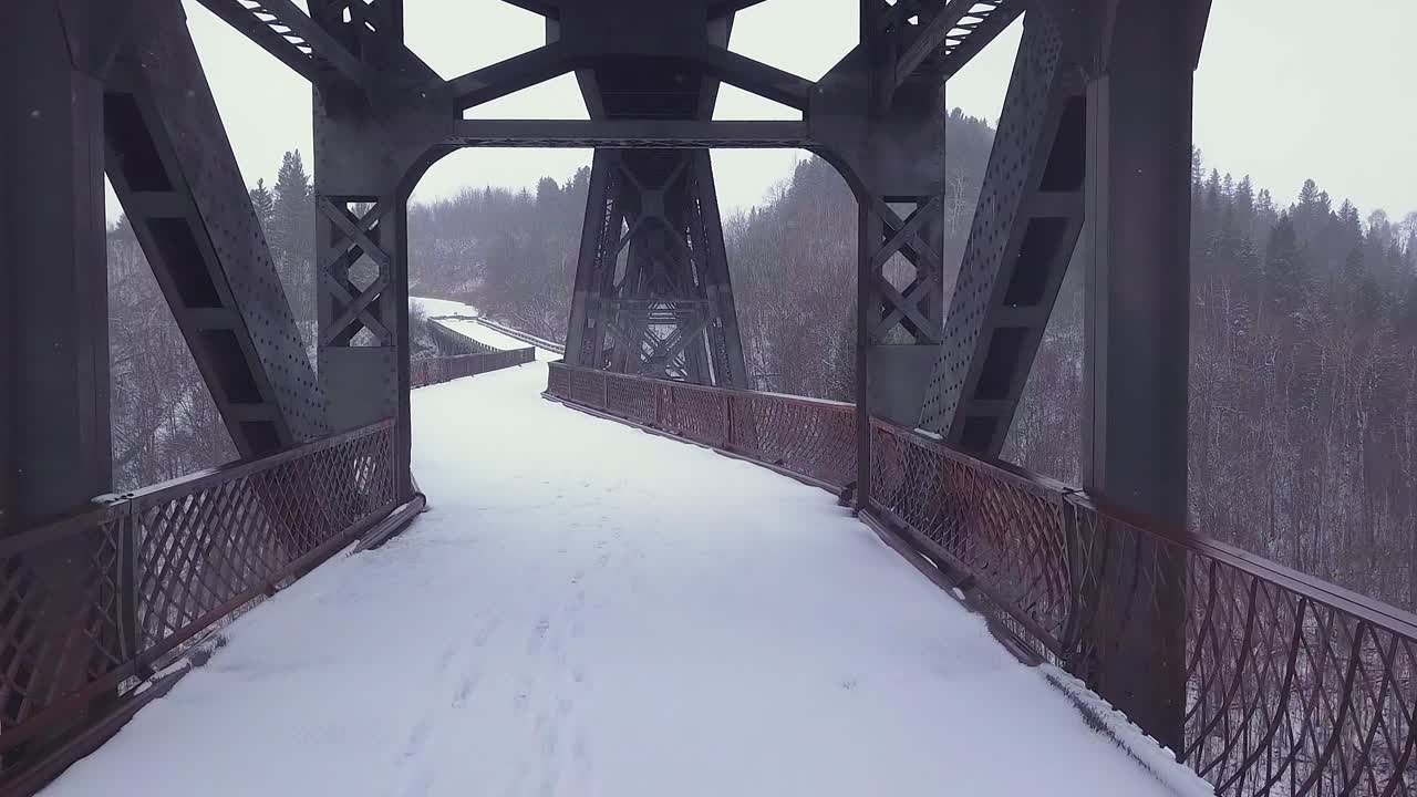 철도 교차로 아래에 버려진 다리 갑판을 따라 단색 겨울 pov
