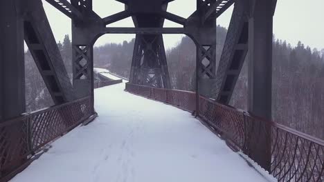 Monochromer-Winter-Pov-Entlang-Des-Verlassenen-Brückendecks-Unter-Dem-Bahnübergang