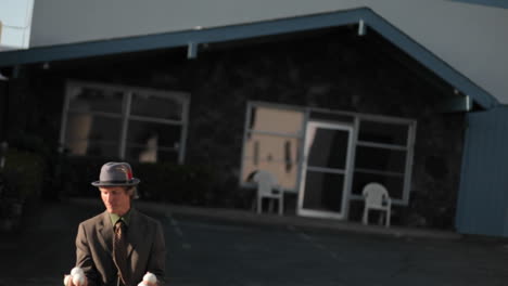 a man starts juggling six balls and drops them all