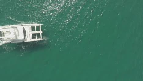 Flying-over-luxurious-big-white-yacht-sailing-in-ocean-leaving-wake