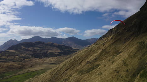 paragliding in wanaka new zealand thru the mountains and hills overlooking a lake near roys peak