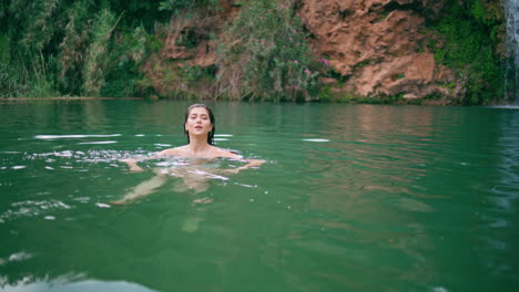 mujer activa buceando en la piscina de la bahía del mar sola. dama feliz nadando en la profunda laguna de verano