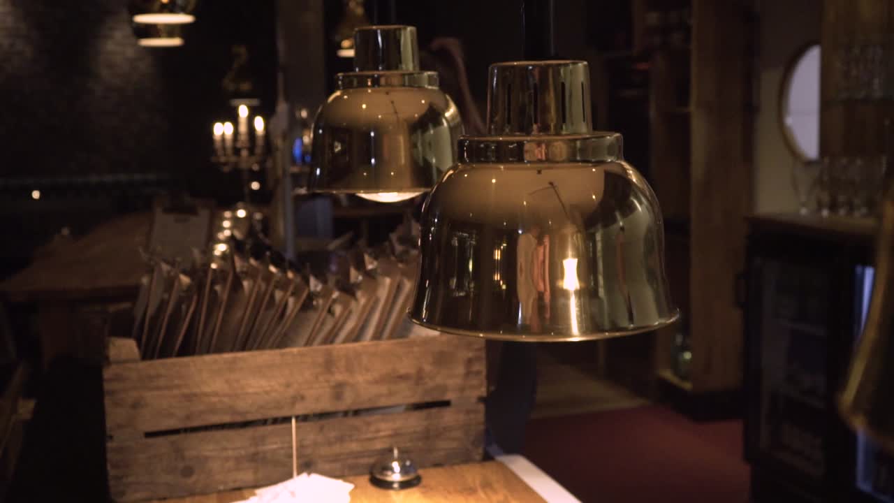 cozy lamps hanging at a counter in a restaurant. dolly zoom with the camera