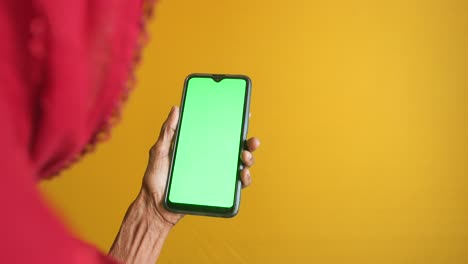 woman holding smartphone with green screen