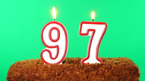 cake with the number 97 lighted candle. chroma key. green screen. isolated
