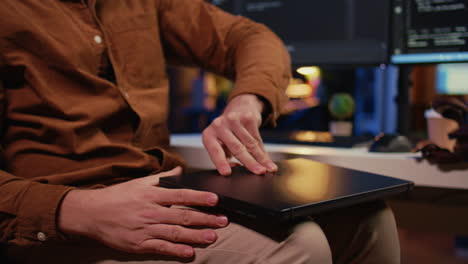 teleworker unpacking backpack, writing lines of code on laptop