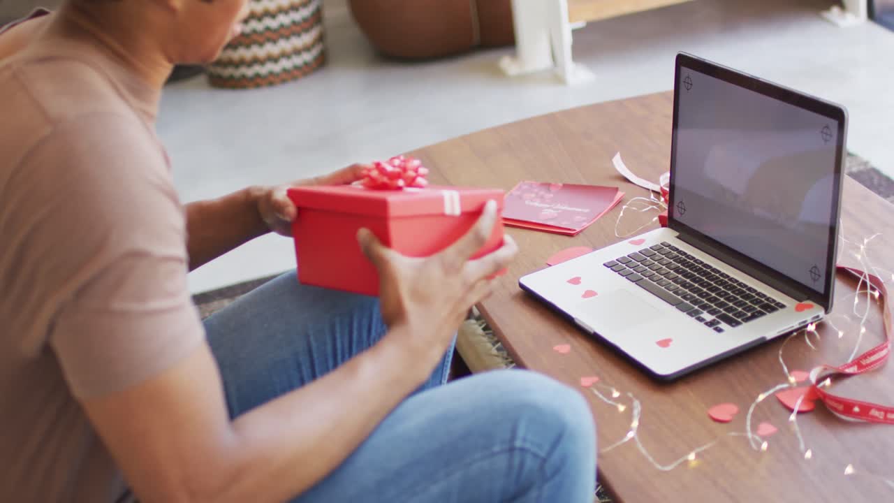 hombre afroamericano hablando en una videollamada usando una computadora portátil en casa