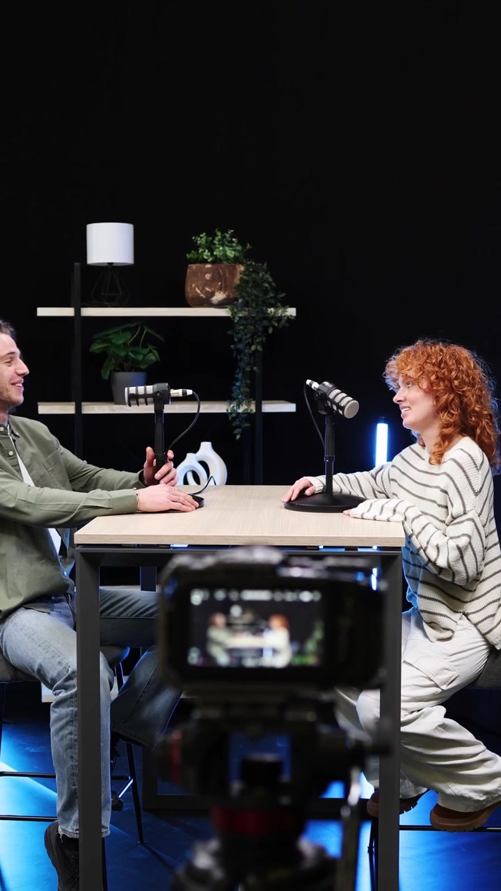 Uomo e donna che registrano un'intervista podcast in uno studio moderno
