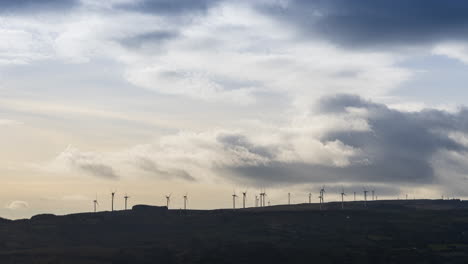 time lapse of wind turbines in remote landscape area during daytime with passing clouds in ireland