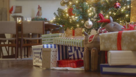 los regalos de navidad se sientan debajo de un árbol.