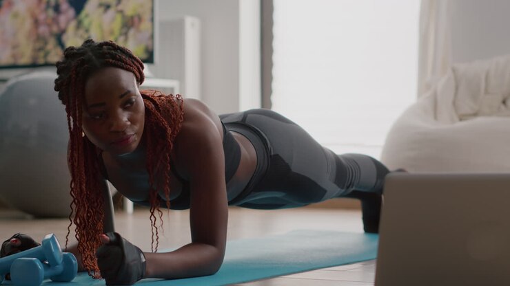 Afro american woman with sportswear stretching yoga exercises on fitness map