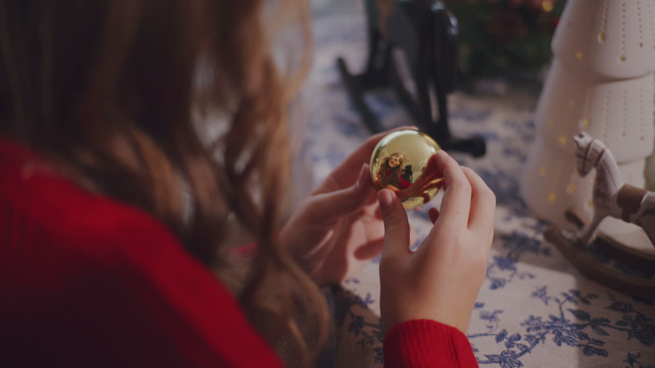 mujer con bauble en la mesa durante la navidad